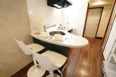 a white table with chairs and a sink in a room at \u30ac\u30a4\u30a2\u6b4c\u821e\u4f0e\u753a203 in Tokyo
