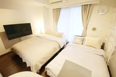 two beds in a small room with a window at \u30ac\u30a4\u30a2\u6b4c\u821e\u4f0e\u753a203 in Tokyo