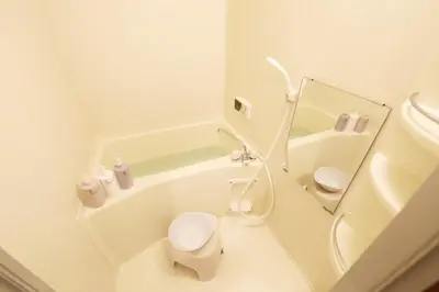 a white bathroom with a toilet and a bath tub at \u30ac\u30a4\u30a2\u6b4c\u821e\u4f0e\u753a203 in Tokyo