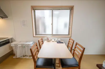 a table and chairs in a kitchen with a window at Elle Maison\u5927\u68ee 102 in Tokyo
