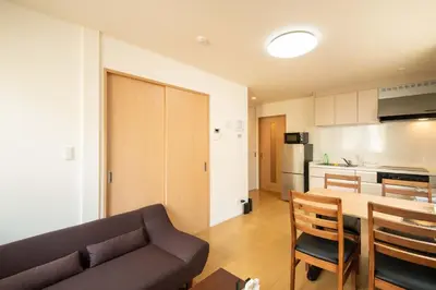 a living room and kitchen with a couch and a table at Elle Maison\u5927\u68ee 102 in Tokyo