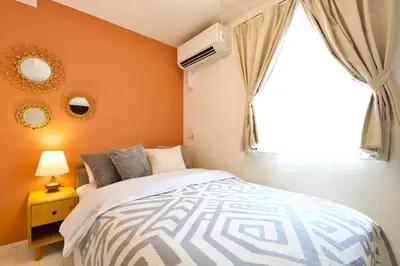 a bedroom with orange walls and a bed and a window at \u30aa\u30fc\u30d6\u30ea\u30aa\u30f3\u6075\u6bd4\u5bff202 in Tokyo