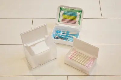 two plastic containers of toothbrushes sitting on a tile floor at \u30aa\u30fc\u30d6\u30ea\u30aa\u30f3\u6075\u6bd4\u5bff202 in Tokyo