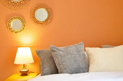 a bedroom with orange walls and a bed with pillows at \u30aa\u30fc\u30d6\u30ea\u30aa\u30f3\u6075\u6bd4\u5bff202 in Tokyo