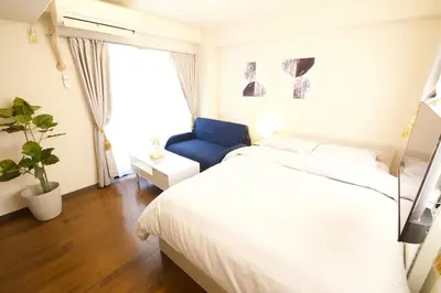 a bedroom with a white bed and a blue chair at \u30b5\u30f3\u30cf\u30a4\u30c4\u521d\u53f0401 in Tokyo
