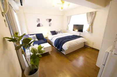 a bedroom with a bed and a tv in it at \u30b5\u30f3\u30cf\u30a4\u30c4\u521d\u53f0401 in Tokyo
