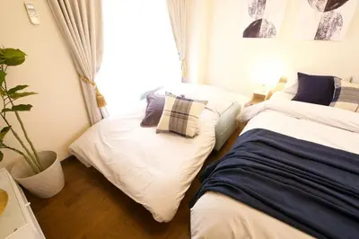 a bedroom with two beds with pillows on them at \u30b5\u30f3\u30cf\u30a4\u30c4\u521d\u53f0401 in Tokyo