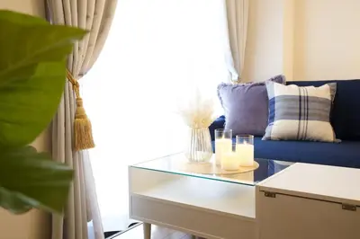 a living room with a blue couch and a glass table at \u30b5\u30f3\u30cf\u30a4\u30c4\u521d\u53f0401 in Tokyo