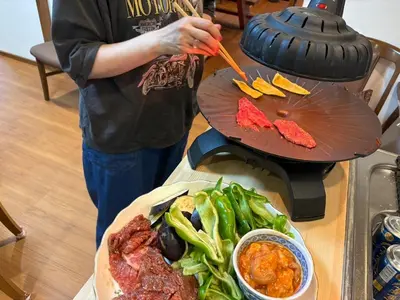 a person is cooking food on a grill at Kenichi Retreat in Tokyo