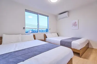 two beds in a room with a window at Birthday House Skytree in Tokyo