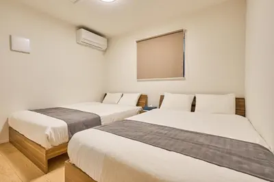 two beds in a room with a mirror at Birthday House Skytree in Tokyo