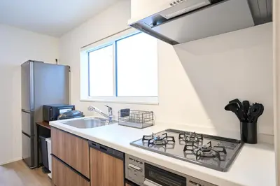 a kitchen with a stove and a sink and a window at Birthday House Skytree in Tokyo