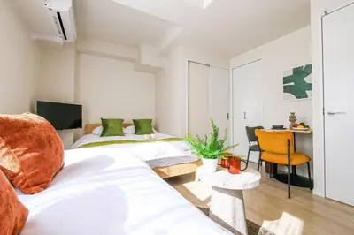 a bedroom with two beds and a table with a chair at Mr Kintaro Hotel Kinshicho in Tokyo