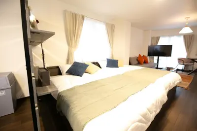 a bedroom with a large white bed in front of a window at studio aoi 302 in Tokyo