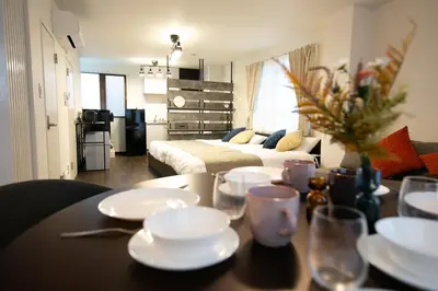 a living room with a table and a bed at studio aoi 302 in Tokyo