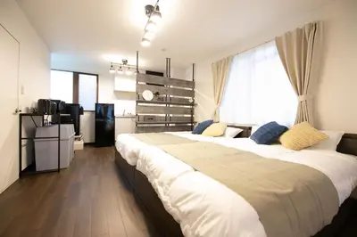 a large bedroom with two beds and a window at studio aoi 302 in Tokyo