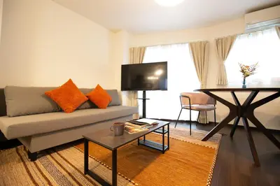 a living room with a couch and a flat screen tv at studio aoi 302 in Tokyo