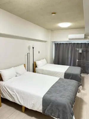 a room with two beds and a window at \u65b0\u5bbf\u533a\u65b0\u5927\u4e45\u4fdd\u304b\u3089\u5f92\u6b6910\u5206\u6b4c\u821e\u4f0e\u753a in Tokyo