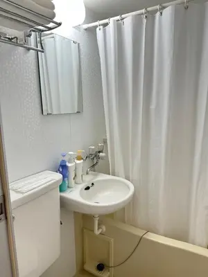 a white bathroom with a sink and a shower curtain at \u65b0\u5bbf\u533a\u65b0\u5927\u4e45\u4fdd\u304b\u3089\u5f92\u6b6910\u5206\u6b4c\u821e\u4f0e\u753a in Tokyo