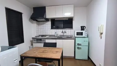 a small kitchen with a wooden table and a green refrigerator at Shinjuku 2bed rooms sunny apart ment#2室1厅阳光公寓#高速无限制网路2&2 in Tokyo