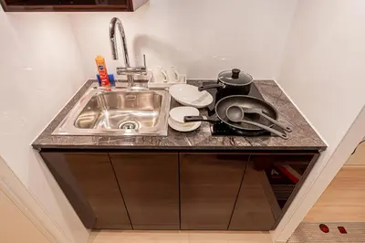 a kitchen counter with a sink and dishes on it at Mi-HOTEL SHIMOKITAZAWA in Tokyo