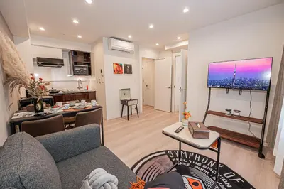 a living room with a couch and a tv at Mi-HOTEL SHIMOKITAZAWA in Tokyo