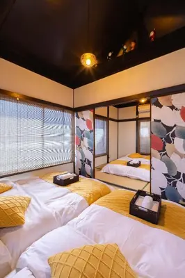 a large room with four beds in it at Tokyo Disneyland\u8eca20\u5206 Shinjuku Akihabara\u96fb\u8eca\u76f4\u901a\u306e\u5927\u6b63\u98a8\u8cb8\u5207\u4e00\u8ed2\u5bb6 in Tokyo