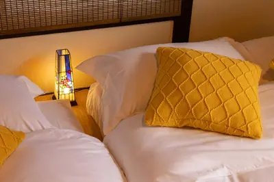 a bedroom with two beds and a yellow pillow at Tokyo Disneyland\u8eca20\u5206 Shinjuku Akihabara\u96fb\u8eca\u76f4\u901a\u306e\u5927\u6b63\u98a8\u8cb8\u5207\u4e00\u8ed2\u5bb6 in Tokyo