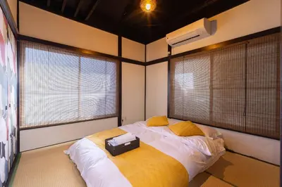 a bedroom with a large bed with two windows at Tokyo Disneyland\u8eca20\u5206 Shinjuku Akihabara\u96fb\u8eca\u76f4\u901a\u306e\u5927\u6b63\u98a8\u8cb8\u5207\u4e00\u8ed2\u5bb6 in Tokyo