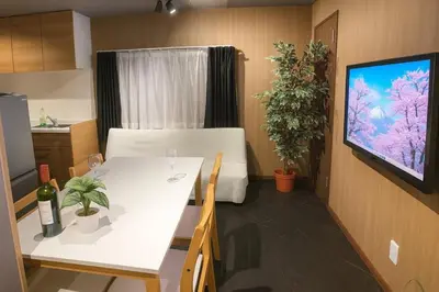 a living room with a white table and a television at OZ nakano in Tokyo