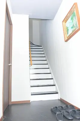a hallway with stairs and a painting on the wall at OZ nakano in Tokyo