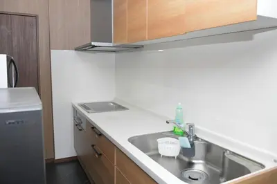 a kitchen with a sink and a refrigerator at OZ nakano in Tokyo