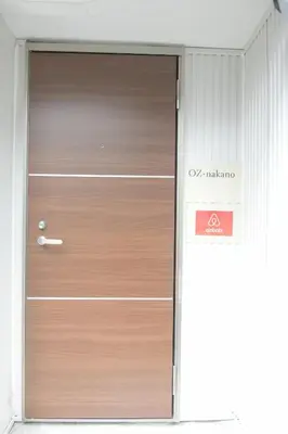 a wooden door in a building with a sign on it at OZ nakano in Tokyo