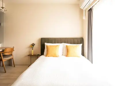 a bedroom with a large bed with yellow pillows at Section L Residence Moto-Azabu in Tokyo
