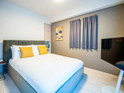 a bedroom with a large bed with yellow pillows at Section L Residence Moto-Azabu in Tokyo