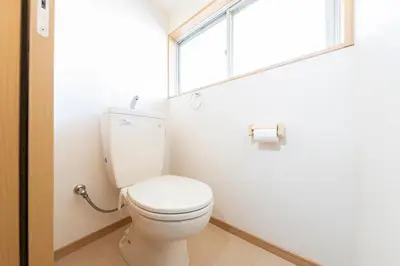 a white toilet in a bathroom with a window at Ayame Building in Tokyo