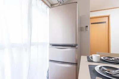 a white refrigerator in a kitchen with a table at Ayame Building in Tokyo