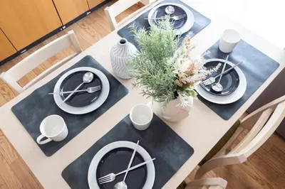 a dining room table with black and white plates and flowers at Ayame Building in Tokyo