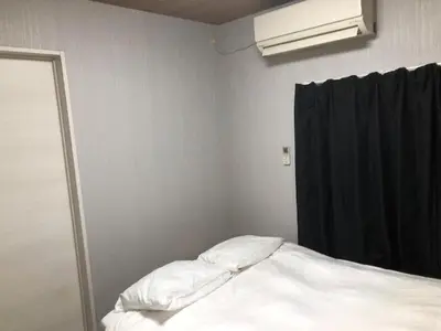 a bedroom with a bed with white sheets and a window at OZ sumida in Tokyo