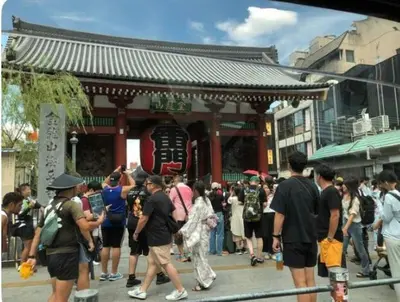 a crowd of people standing in front of a temple at OZ sumida in Tokyo