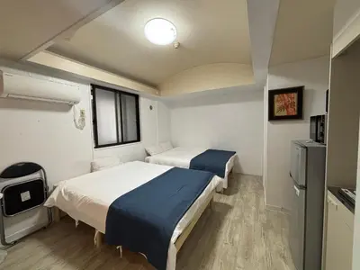 a room with two beds and a window at \u82b1\u4e43\u90f7\u6c60\u888b4\u4e01\u76ee in Tokyo