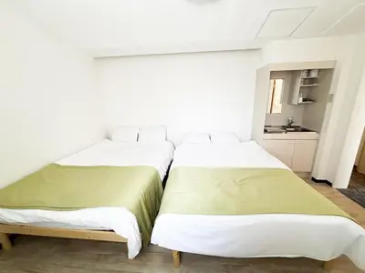 two beds sitting next to each other in a room at \u82b1\u4e43\u90f7\u6c60\u888b4\u4e01\u76ee in Tokyo
