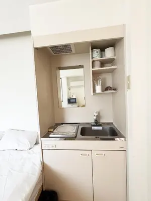 a small kitchen with a sink and a bed at \u82b1\u4e43\u90f7\u6c60\u888b4\u4e01\u76ee in Tokyo