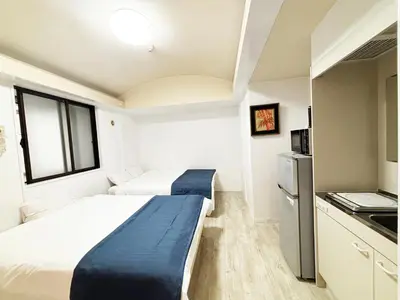 a small bedroom with two beds and a kitchen at \u82b1\u4e43\u90f7\u6c60\u888b4\u4e01\u76ee in Tokyo