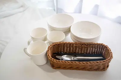 a basket of cups and utensils on a table at Urban Nest Otsuka 301 JR OTSUKA STATION in Tokyo