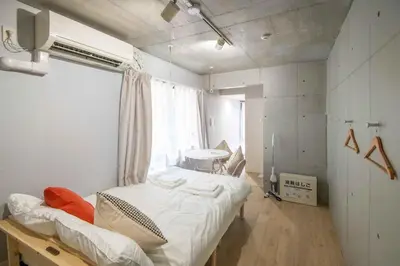 a bedroom with a bed and a table and a window at Urban Nest Otsuka 301 JR OTSUKA STATION in Tokyo