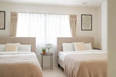 a bedroom with two beds and a window at HOTEL AndPlace Sasaduka in Tokyo