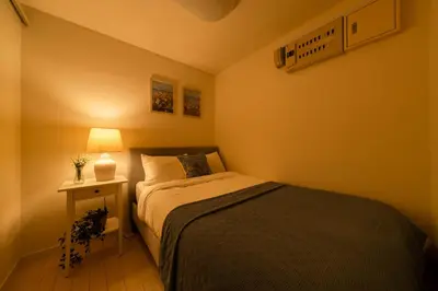 a small bedroom with a bed and a lamp at HOTEL AndPlace Sasaduka in Tokyo