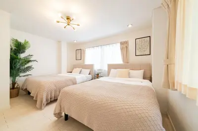 a bedroom with two beds and a ceiling fan at HOTEL AndPlace Sasaduka in Tokyo