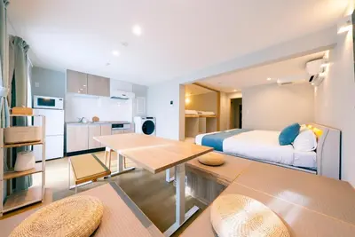 a bedroom with a bed and a kitchen with a table at Asakusa Sky Tokyo Condominium hotel in Tokyo